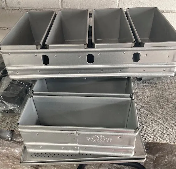 A coated commercial bakery bread tray