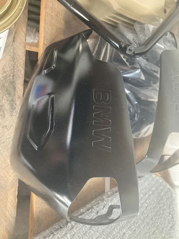 A matte-black ceramic-coated BMW motorcycle engine cover on the workshop bench