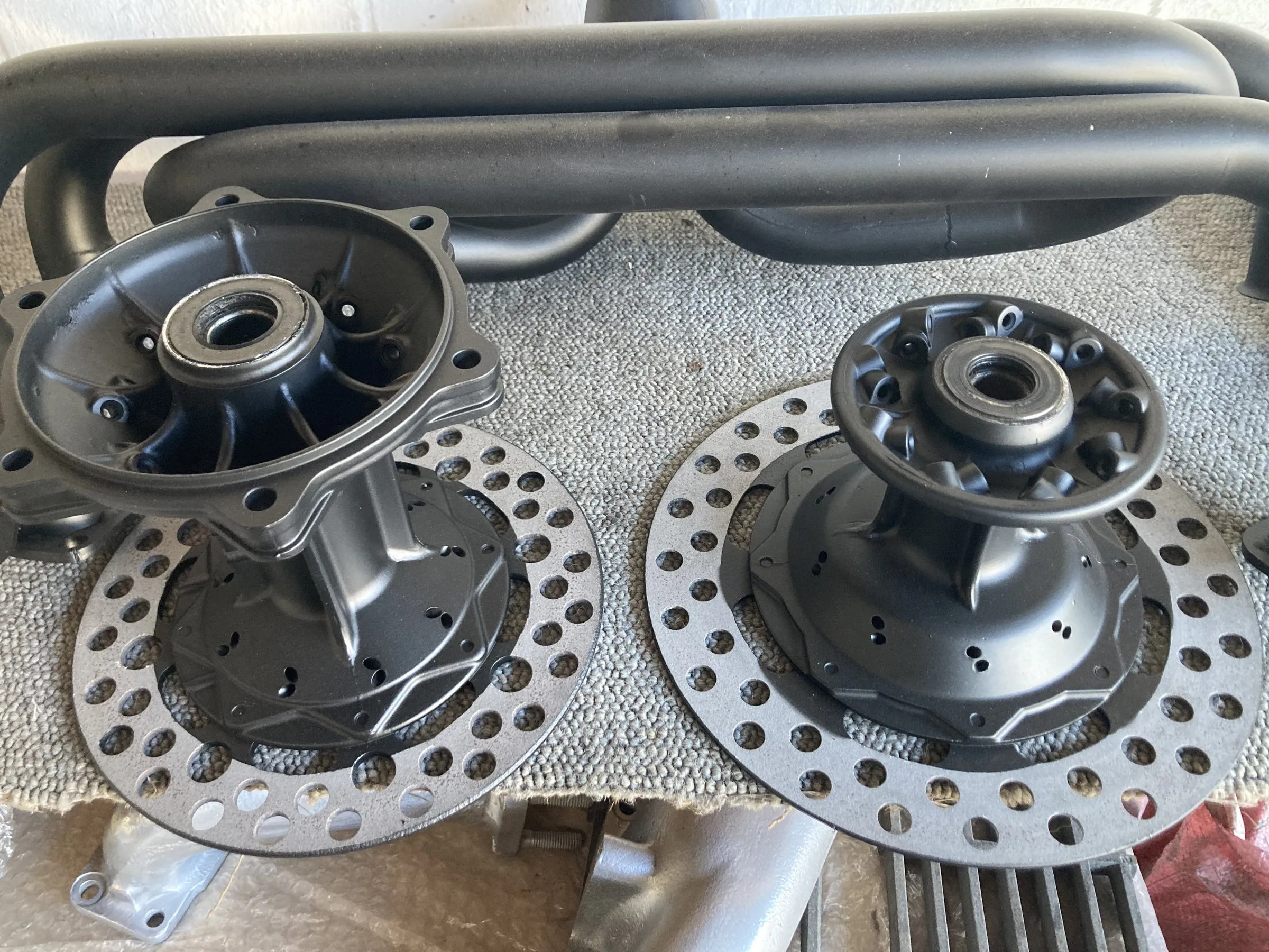 A pair of ceramic-coated motorcycle wheel hubs and brake discs